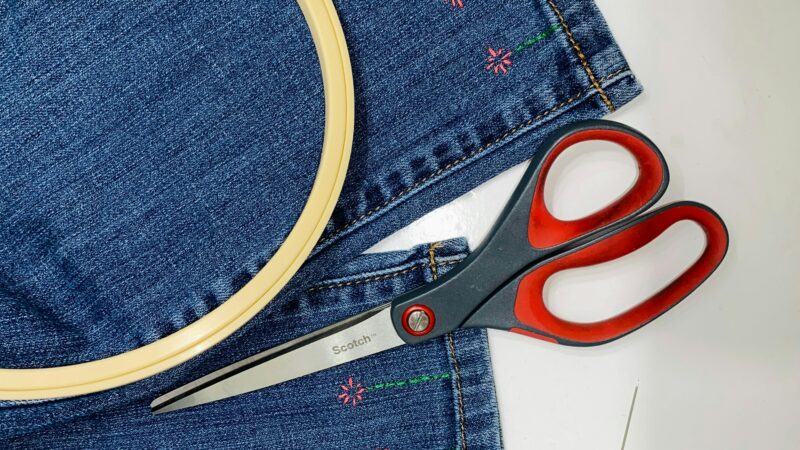 couture d'un jean avec une paire de ciseaux
