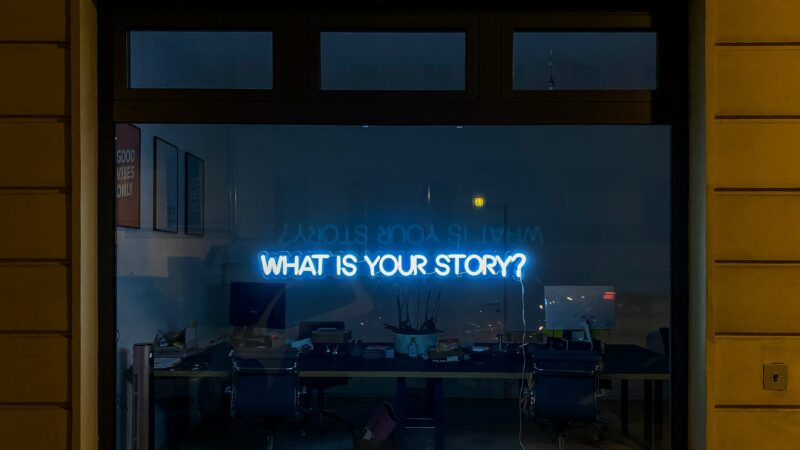Vitrine avec Néon indiquant "what is your story"