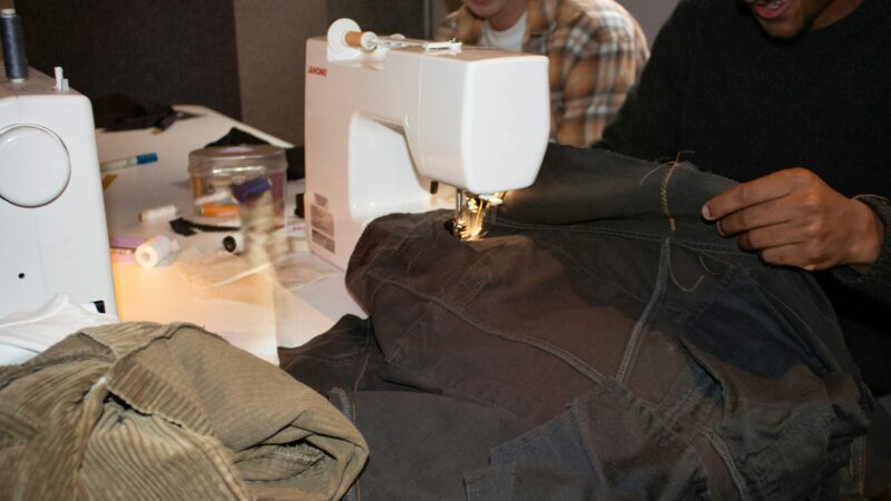 Des gens cousent des vêtements avec une machine à coudre